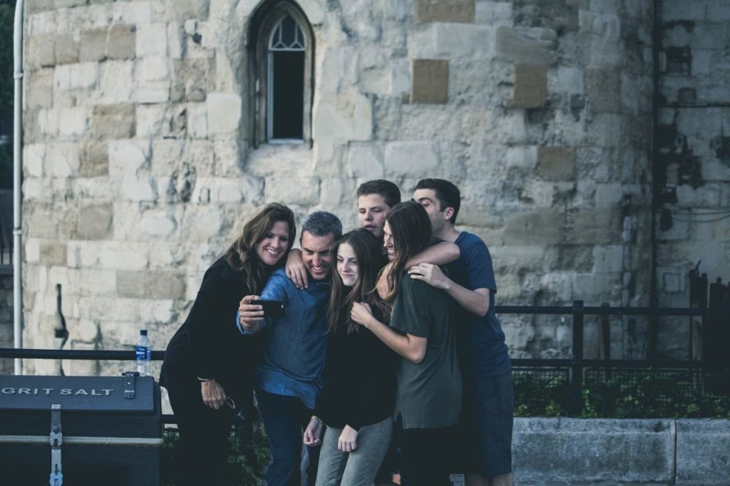 Group of friends enjoying a moment together while taking a selfie outdoors.